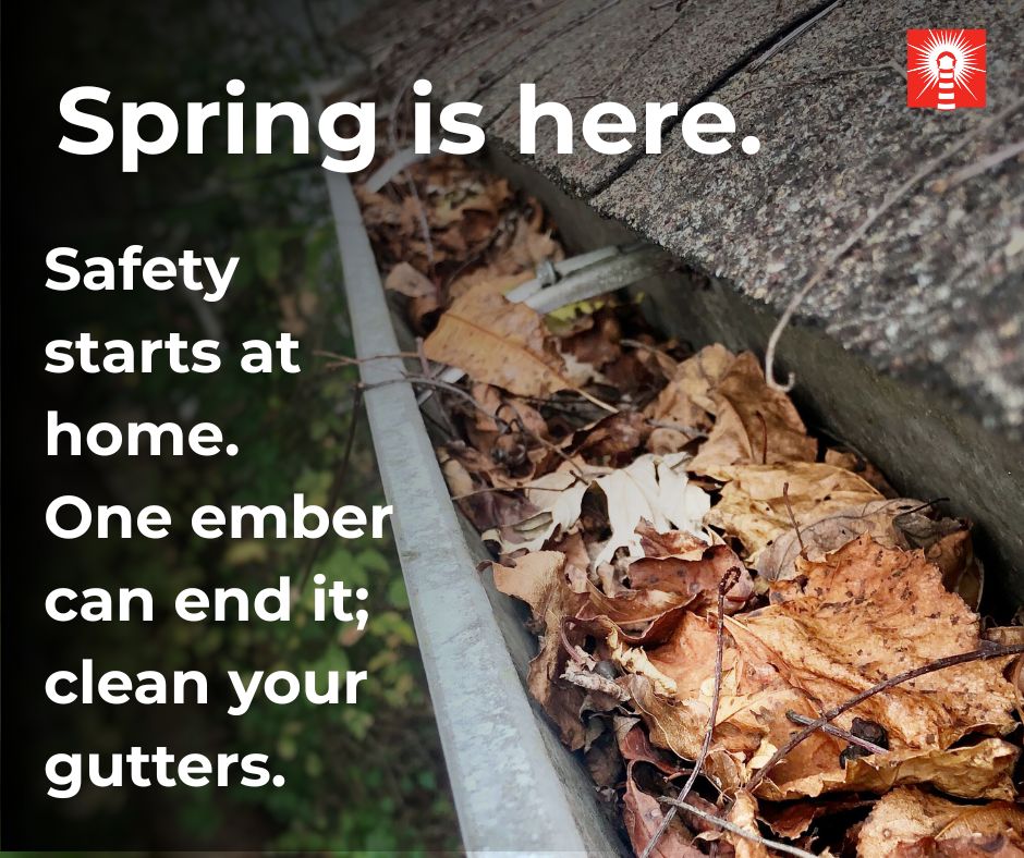 Dry leaves in a roof gutter — spring fire safety reminder.