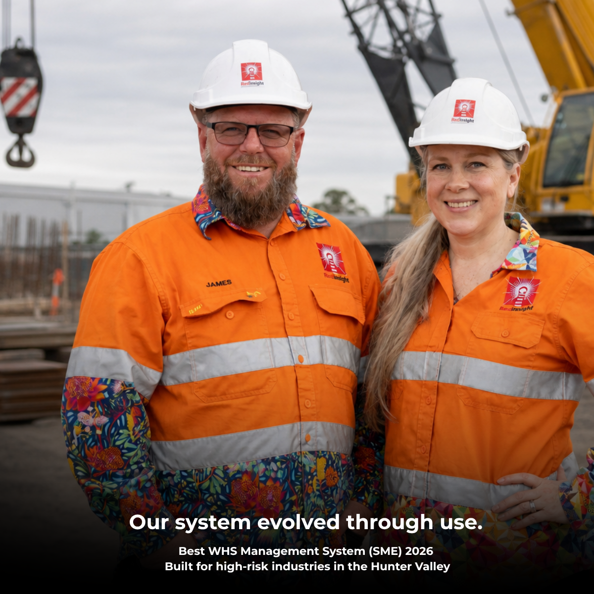 James Brown and Monica Toews Brown from Red Insight standing onsite in PPE in front of heavy construction equipment, representing practical WHS systems built for high-risk industries in the Hunter Valley.